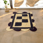 Handwoven scalloped jute rug with natural beige tones, showcasing wavy edges and textured fibers in a coastal-themed living room